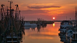 Un port de plaisance avec des bateaux amarrés au coucher du soleil.