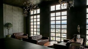 A spacious room with large windows, a long table, and several seating areas. - Miravé San José Escalante (San Jose)