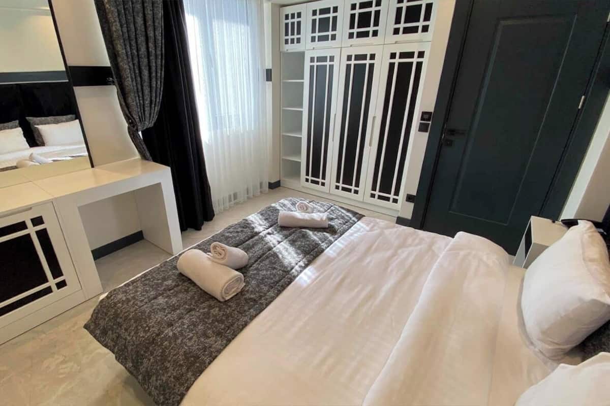 Ein Hotelzimmer mit Bett, Nachttisch und Kleiderschrank.