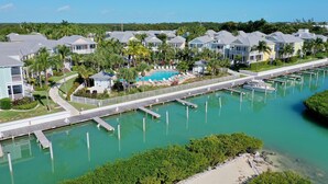 Un quartier résidentiel situé sur la côte, avec des maisons, un port de plaisance et une piscine.