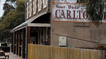 Un edificio con un letrero que anuncia 'Carlton Lunch Tea' y 'Your Beer'.