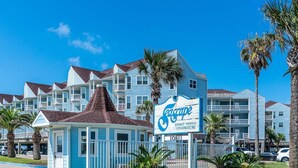 Ein Resort mit einem Schild, auf dem „Teescape Resort Rental Condominiums“ steht, und einer kleinen, pavillongleichen Konstruktion.
