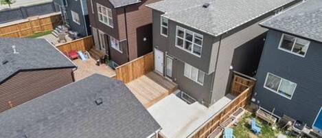 A residential area with modern houses, a wooden deck, and outdoor seating.