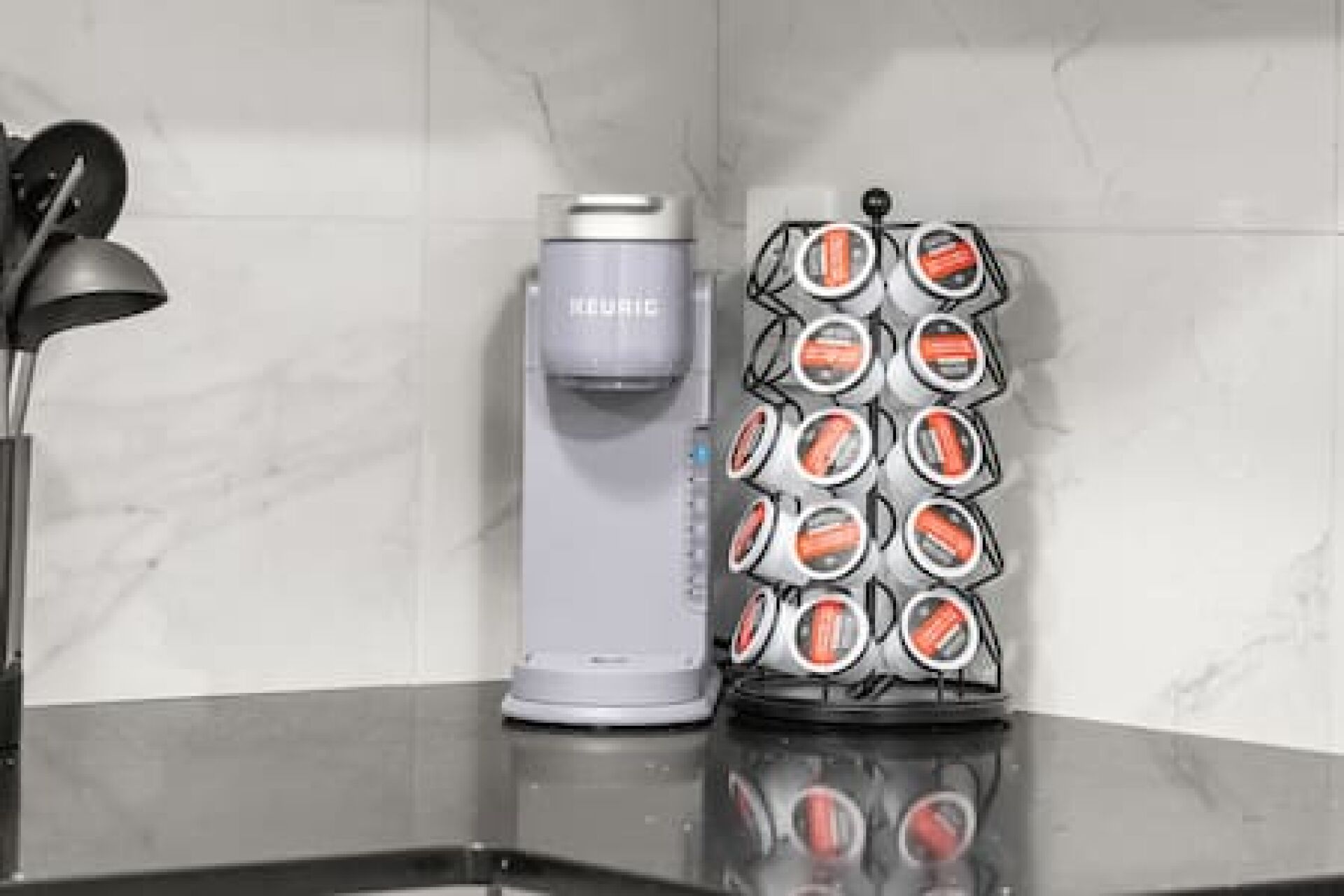 A kitchen counter with a coffee maker and a stack of orange and white containers.