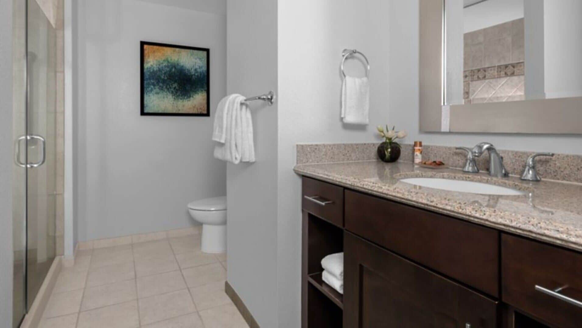 Une salle de bain moderne équipée d’une douche, de toilettes et d’un lavabo.
