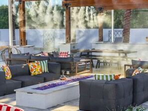 Une terrasse extérieure dotée d’un foyer, d’un espace salon et d’une table.