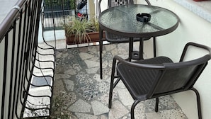 A balcony with a round table and two chairs, potted plants, and a railing. - Ceciaìs House ROOM 2 (Bassano del Grappa)