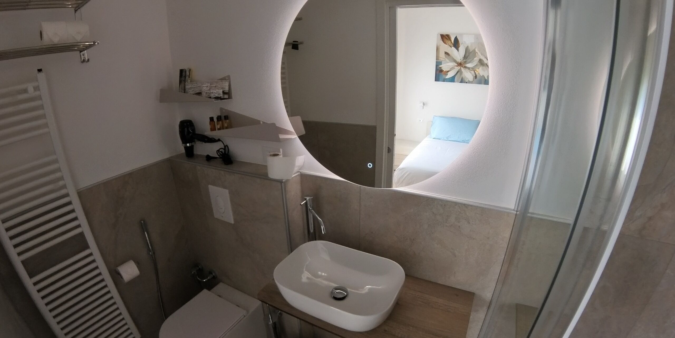 A bathroom with a white sink, a mirror, and a shower.