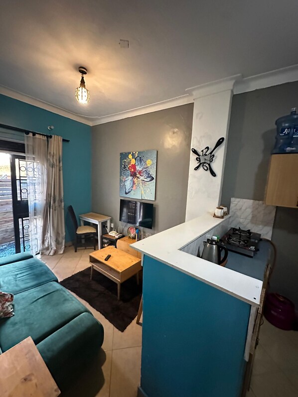 A compact living space with a kitchenette, a dining area, and a sofa.