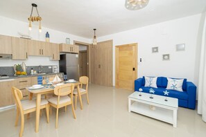 Un appartement moderne comprenant une cuisine, un coin repas et un salon.
