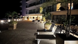 A modern hotel with multiple balconies, outdoor seating, and potted plants. - Modern Studio with Ocean View (Cruz de Huanacaxtle)