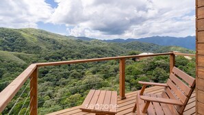 A wooden deck with a bench overlooking a lush green valley and distant mountains. - Apt w/ Fireplace, Jacuzzi, and Amazing View Vst027 (Anitapolis)
