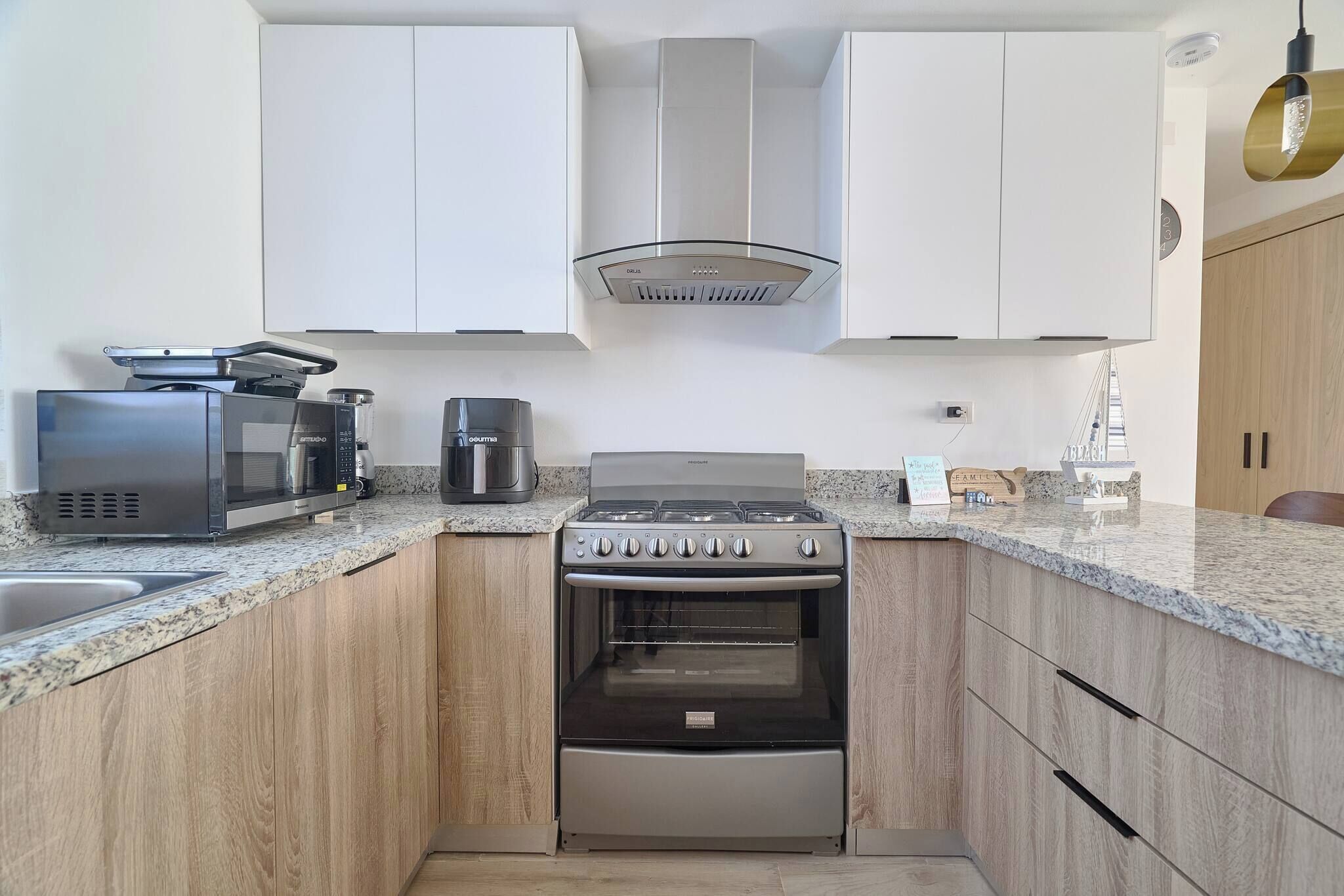 A modern kitchen with a built-in oven, a coffee maker, and a microwave.