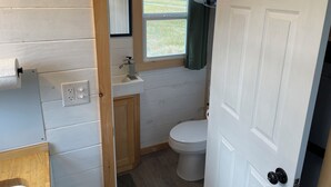 A compact bathroom with a toilet, sink, and window.