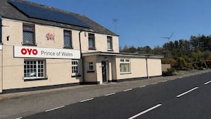 A building with a sign reading 'OYO Prince of Wales' and solar panels on the roof. - OYO Prince of Wales Country Hotel (Princetown)