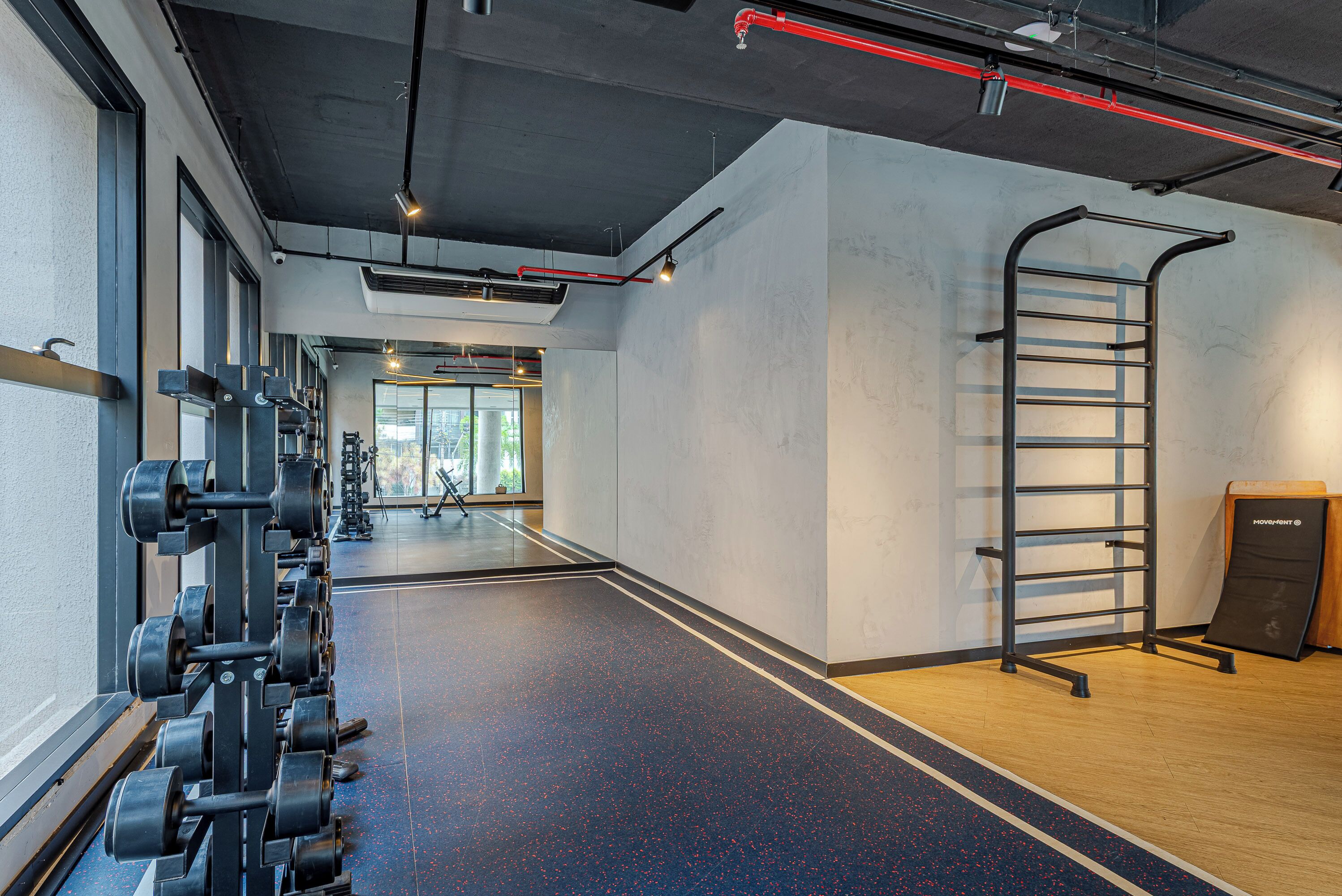 A gym with weight racks, a pull-up bar, and a mirror.