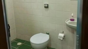 Une salle de bain avec des toilettes, un lavabo et un miroir.