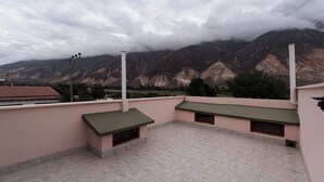 A rooftop terrace with a view of mountains and clouds. - Ñañitas Tampu Wasi (Maimara)