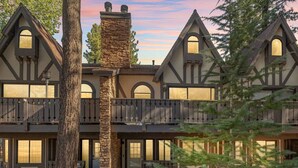 A multi-story building with a stone chimney, multiple windows, and a balcony. - Edge of the Run @ Snow Summit - Easy Walk to Lifts (Big Bear Lake)