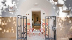 A hotel entrance with a sign, a bed visible inside, and red folding chairs outside. - Laggetto Corner (Otranto)