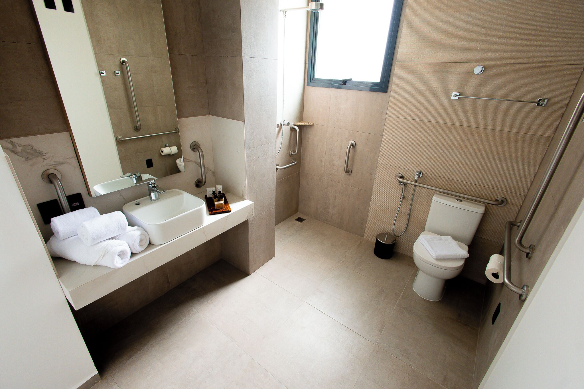 Un baño moderno con lavabo, espejo y retrete.