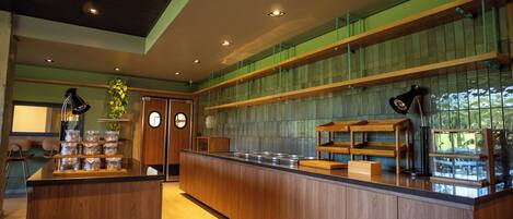 Una cocina moderna con armarios de madera, una isla central y un salpicadero de azulejos verdes.