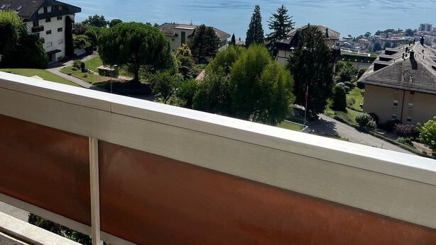 A balcony with a view of a lake and mountains.