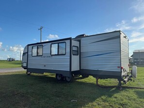 A motorhome with a sliding door, a small window, and a side panel.