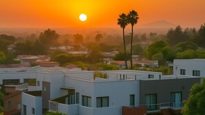 Ein modernes Wohngebiet mit zeitgenössischer Architektur und einem Sonnenuntergang im Hintergrund.