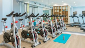 Ein Fitnessstudio mit Ergometer, Laufbändern und einer Spiegelwand.