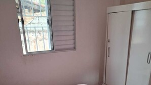 A bedroom with a bed, a wardrobe, and a window. - House with pool in Caraguatatuba, rustic and modern - Porto Novo beach (Barranco Alto Caraguatatuba)