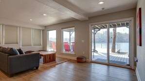 Un salon spacieux avec une grande fenêtre, un canapé et une table basse en bois.