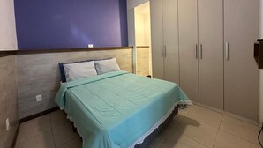 Un dormitorio con cama, armario y ventilador de techo.