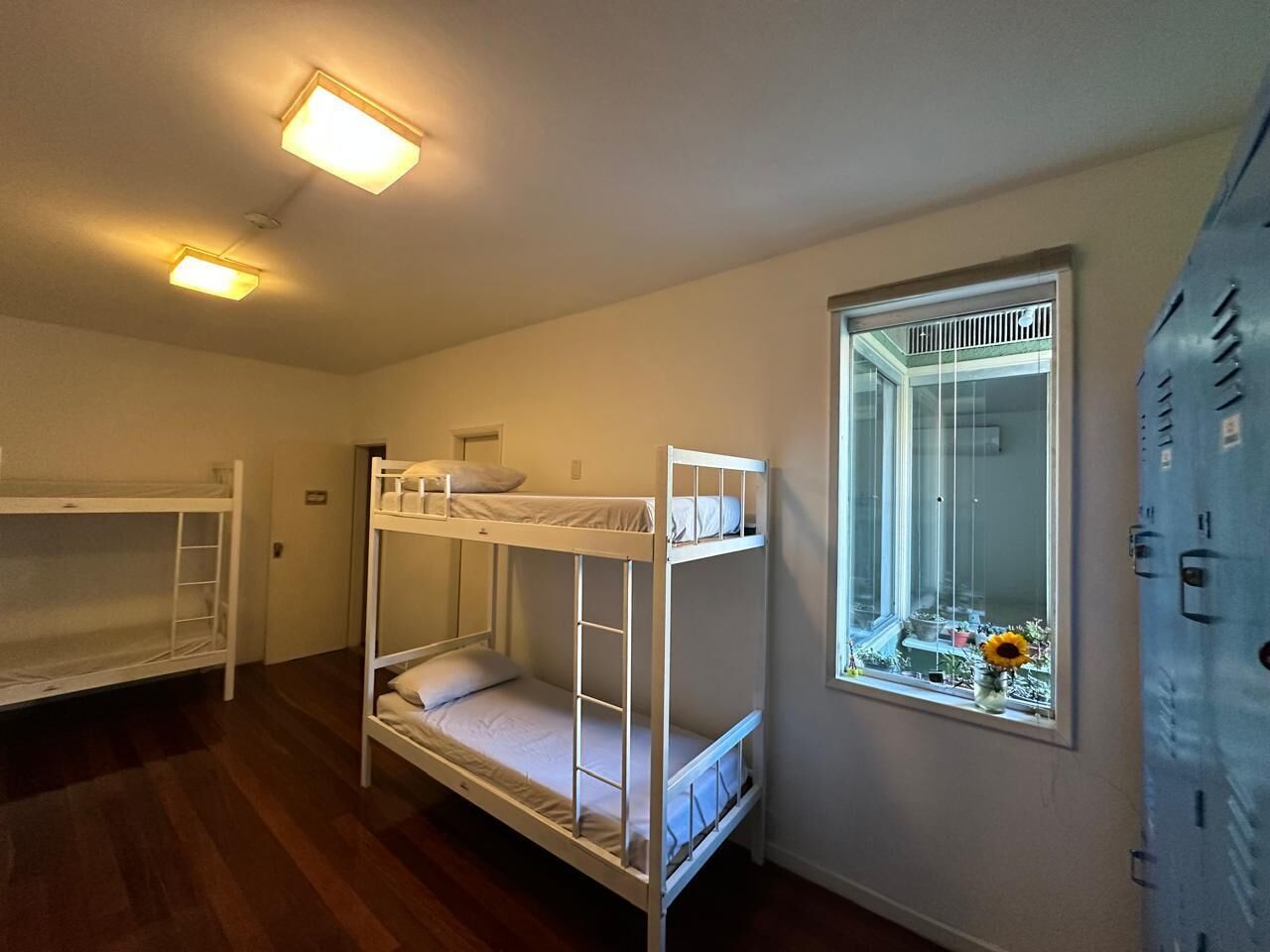A room with bunk beds, a window with a view, and a door with a lock.