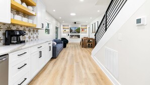 A modern kitchen with white cabinets, a built-in stove, and a coffee maker. - Lakefront 4BR, Hot Tub, Kayaks, Paddleboards, Fire pit, Fireplace, Pool Table (Littleton)
