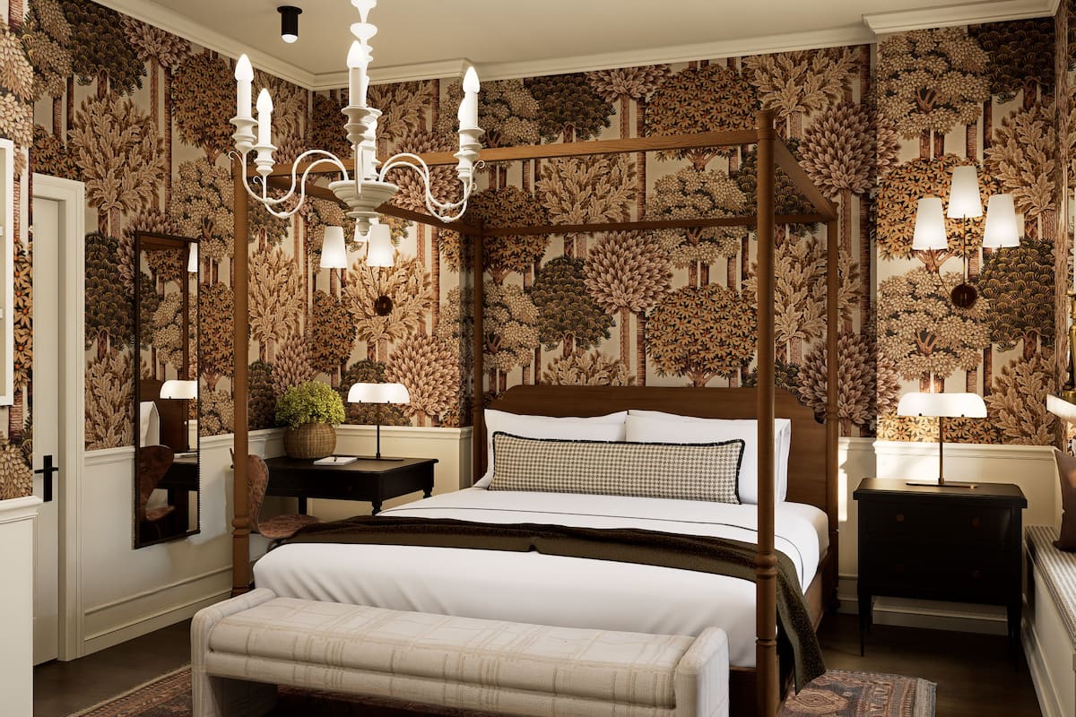 A bedroom with a four-poster bed, a chandelier, and a patterned wallpaper.