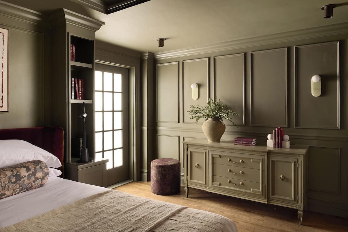 A bedroom with a bed, a nightstand, a dresser, a window, and a bookshelf.