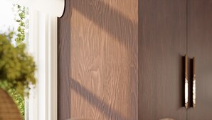 A wooden cabinet with a handle, a window with a view of greenery, and a chair with a textured backrest. - Cambridge Common House (Cambridge)