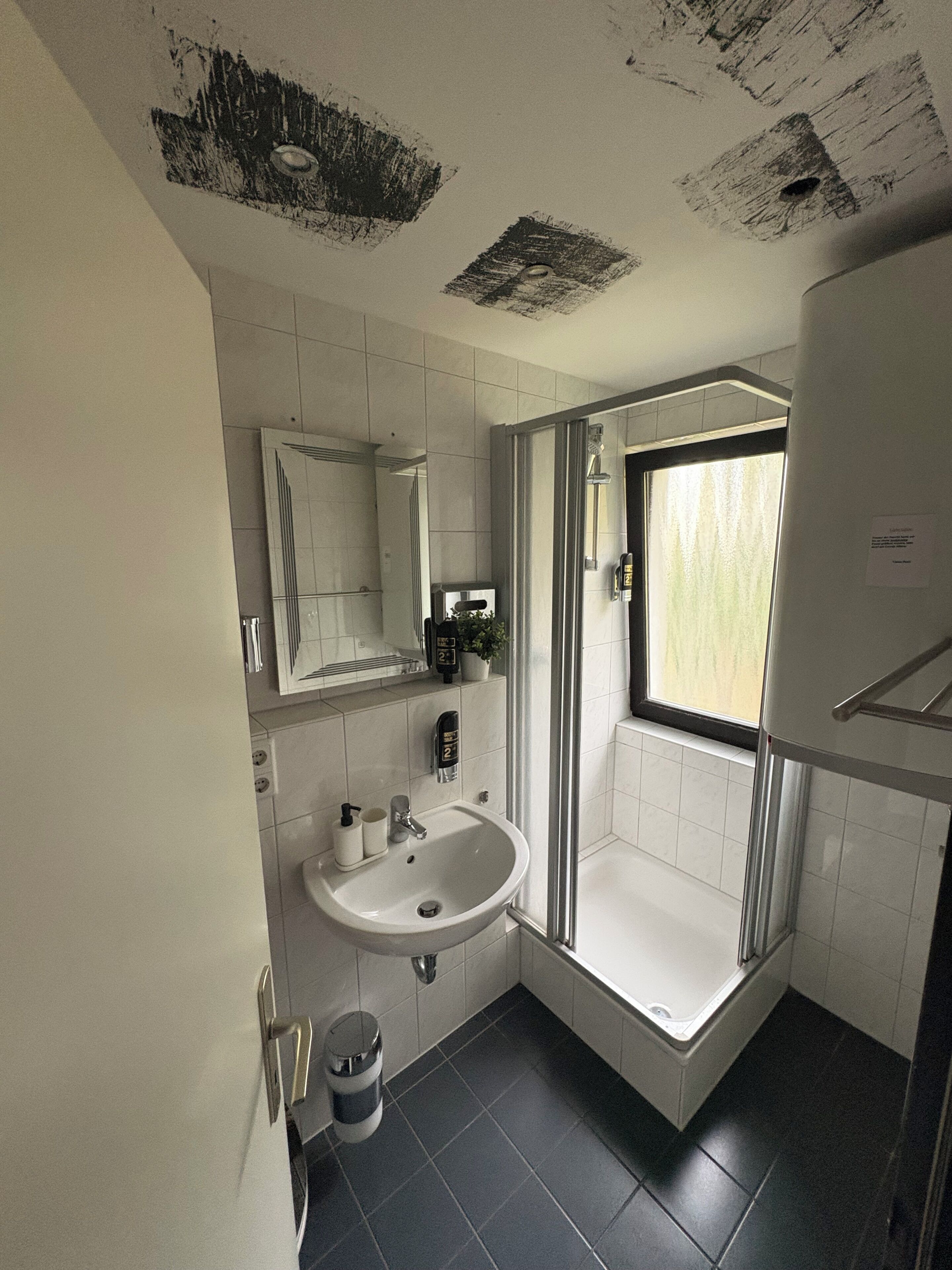 A modern bathroom with a sink, mirror, and shower.