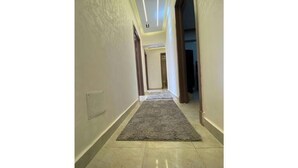 A hallway with a grey carpet and light-colored walls. - Alrehab and awesome (Cairo Governorate)