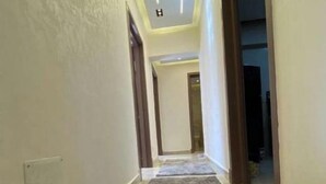 A hallway with a grey carpet and light-colored walls. - Alrehab and awesome (Cairo Governorate)