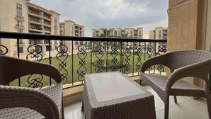 A balcony with wicker furniture and a view of apartment buildings. - Alrehab cozy apartment (Cairo Governorate)