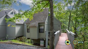 A cabin with a wooden deck and a signboard. - Treehouse Mountain Stay - unique cozy quiet! (Basye)