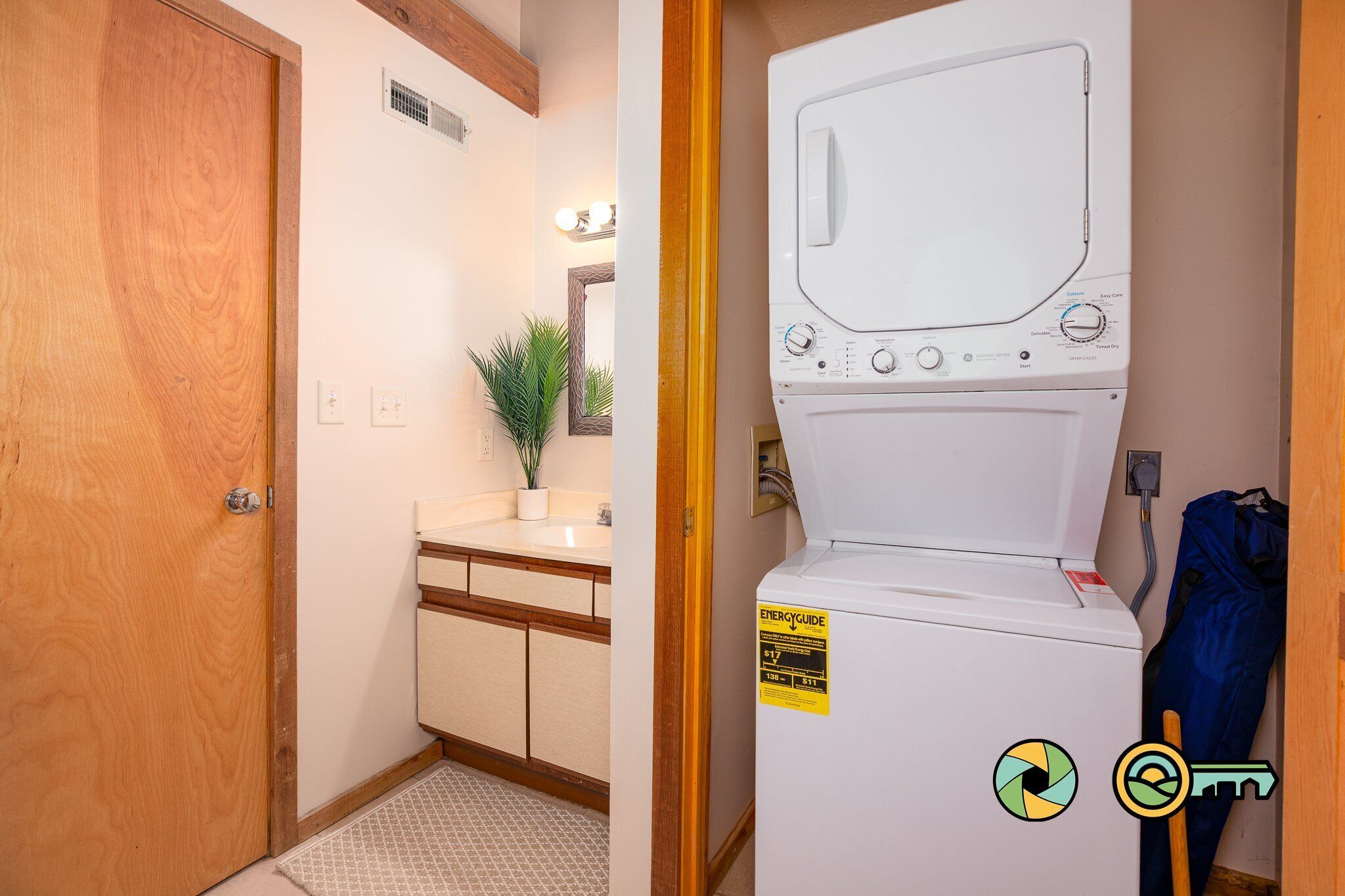 A laundry room with a washing machine, a sink, and a mirror.
