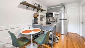 A compact kitchen with a central island, a microwave, a refrigerator, and a coffee machine. - 5BR Group House | Fire Pit, Movie Deck & Fun Games (Charleston)