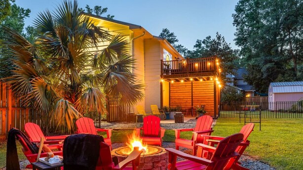 A house with a deck, outdoor seating, and a fire pit. - 5BR Group House | Fire Pit, Movie Deck & Fun Games (Charleston)