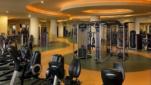 Un gimnasio con máquinas de cardio, equipo de levantamiento de pesas y diversas máquinas de ejercicio.