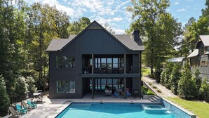 Een tweelaags huis met een ruime voortuin en een zwembad.