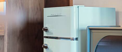 A vintage-style refrigerator with a metallic handle and a label that reads "MAGIC CHEF."