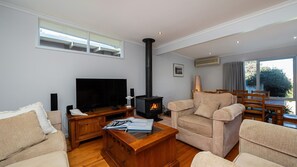 Een smart-tv, een open haard, boeken en een stereo